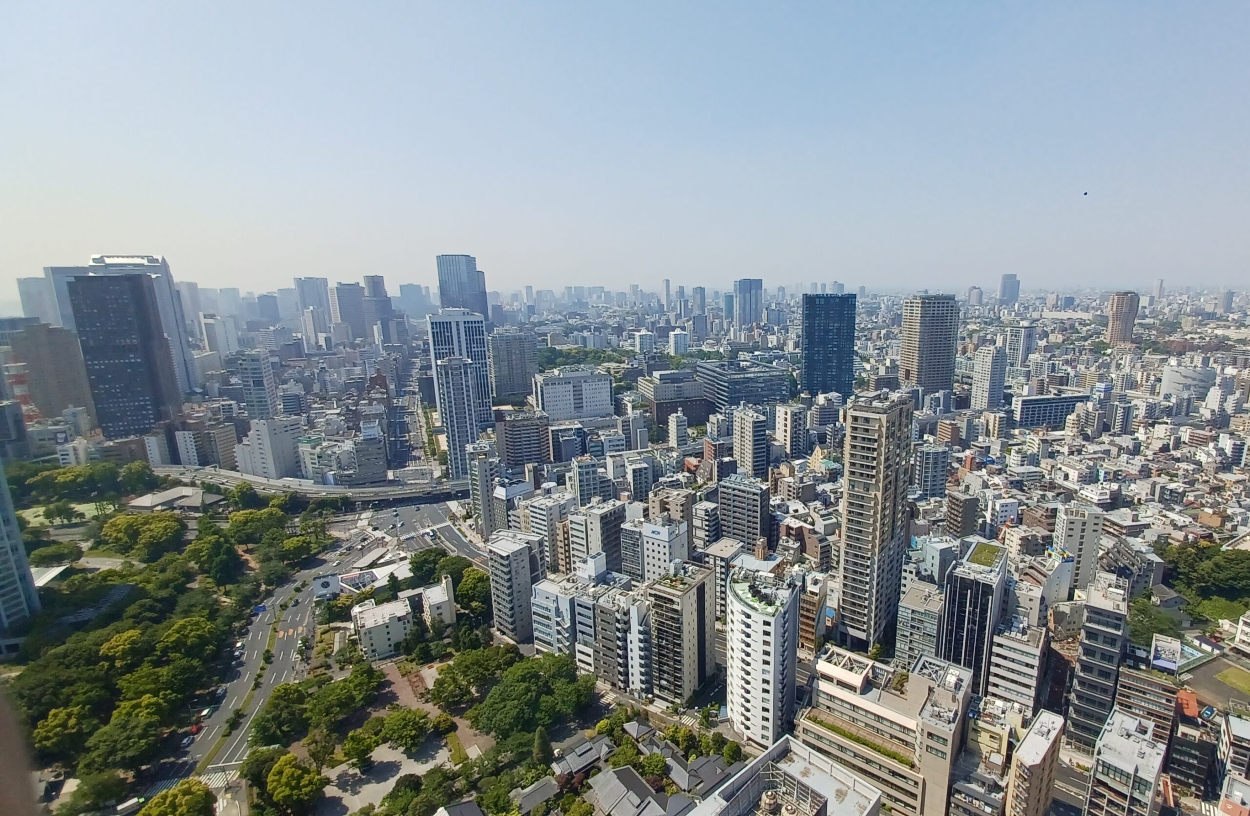 A bunch of high skyscrapers and some green areas (trees), view from Tokyo Tower.