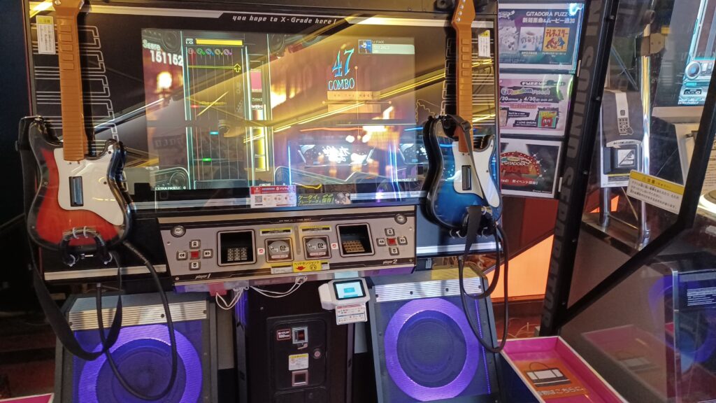 A music game machine with a red guitar on the left and a blue guitar on the right.