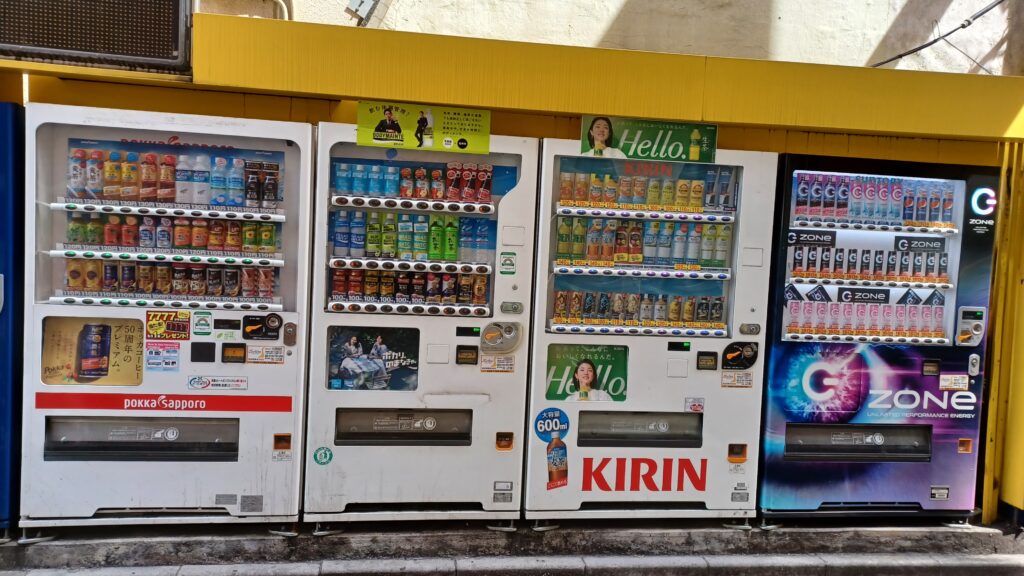 Four vending machines standing next to each other, with a variety of drinks  to choose from.