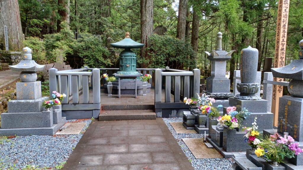 Tombstones on the left and right side with flower bouquets in front of them. 