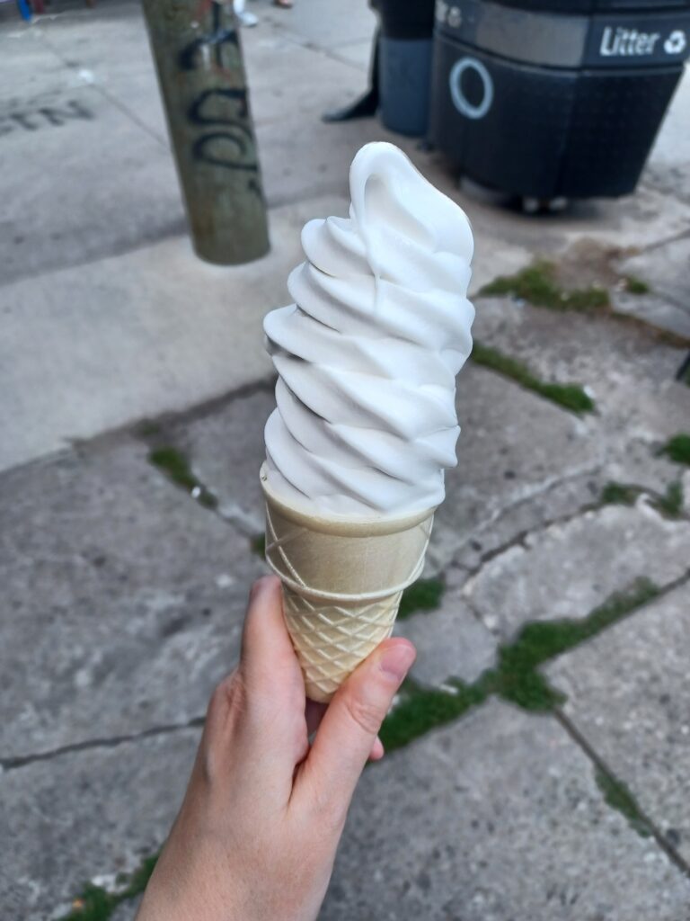 A large white vanilla ice cream cone.