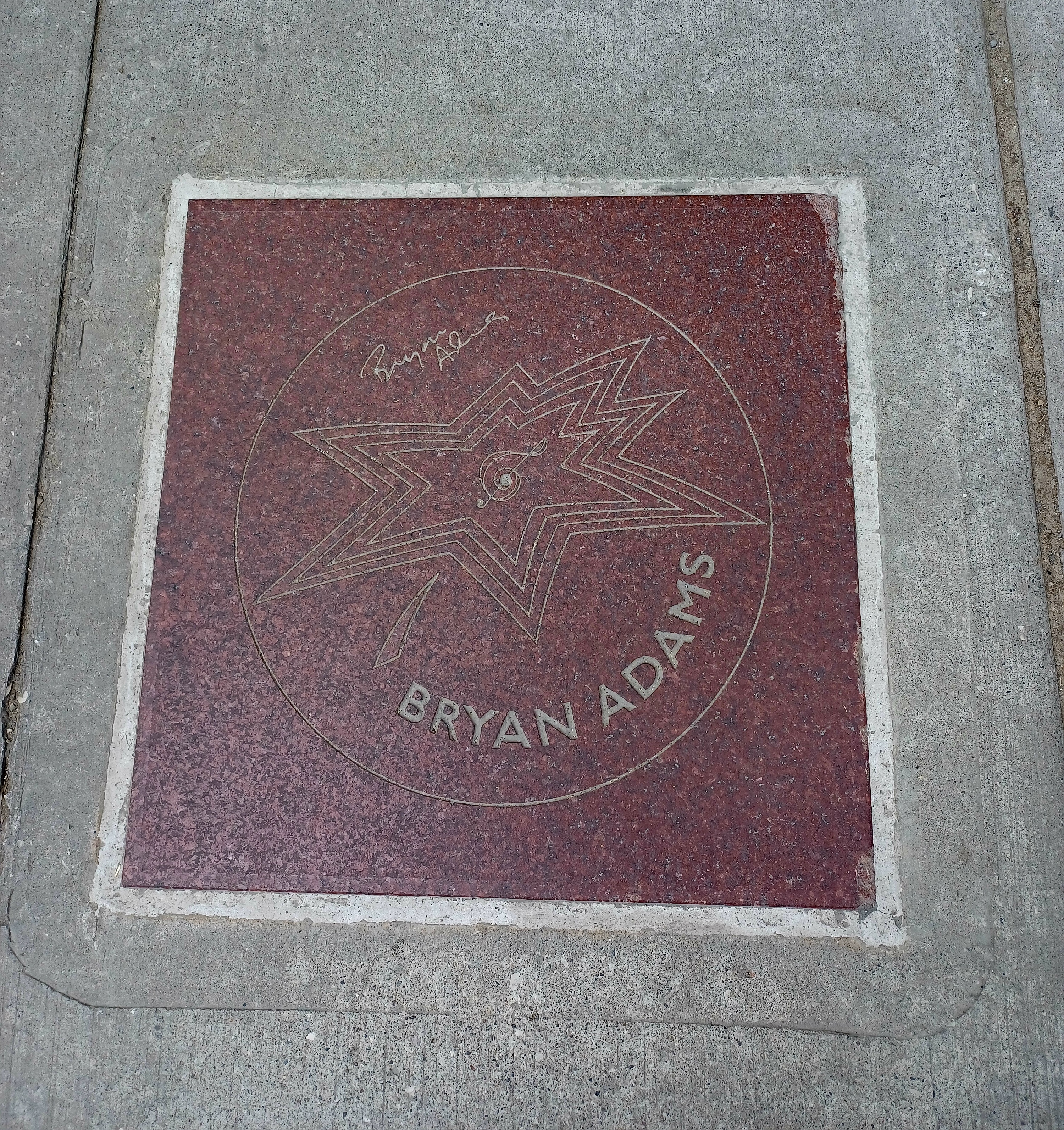 A red star shaped like a maple leaf, that says "Bryan Adams".