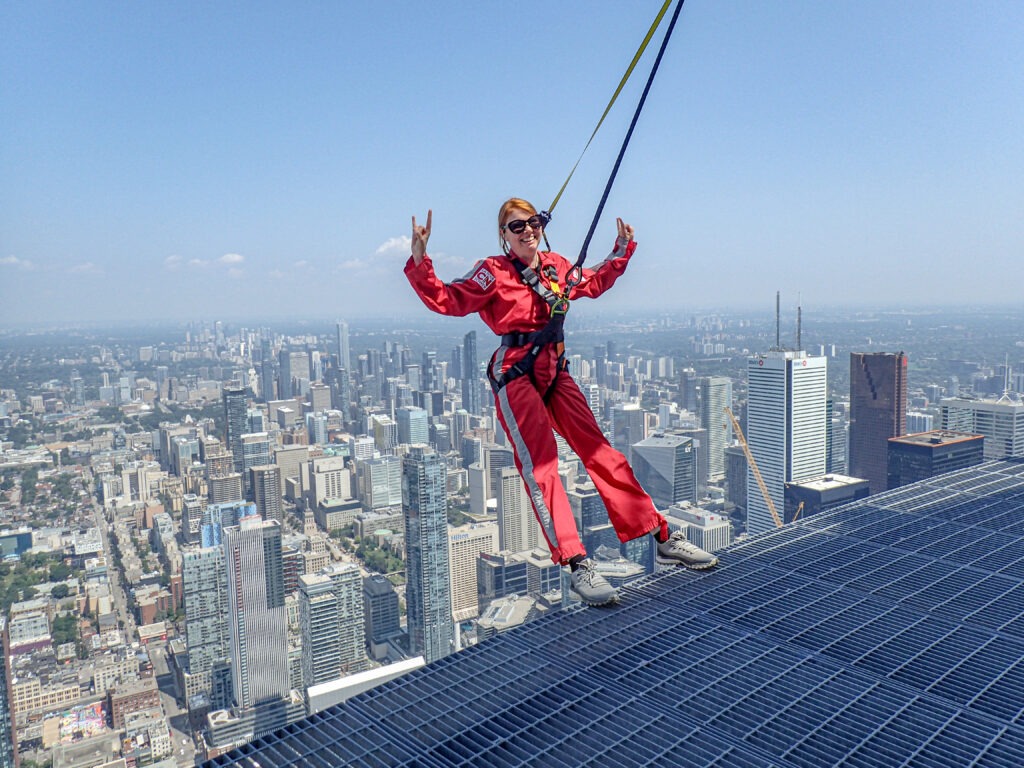 Myself being secured to a rope and harness, leaning back, with Toronto's skyscrapers in the background. 