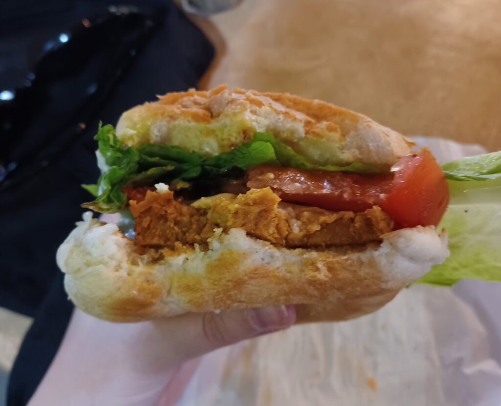A large vegetarian sandwich that features lettuce, tomato, and seitan fake meat.