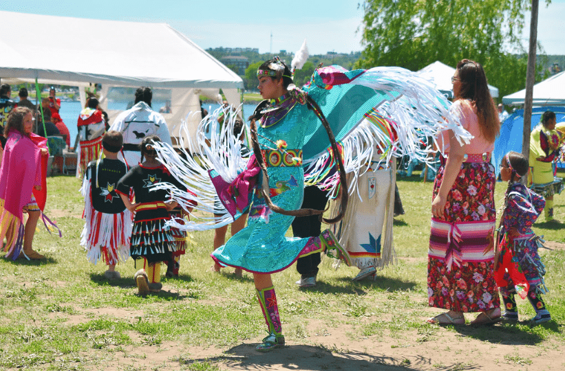 Indigenous performers dancing in their traditional clothing.