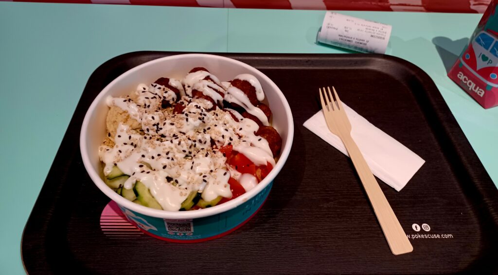 A large bowl on a dark brown tray of the foods mentioned in the text above. There's a wooden fork and napkin as well. 