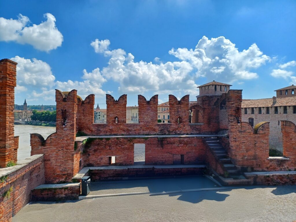 A selection of M-shaped merlons with steps leading up to them on the right. They are all built out of red brick stones.